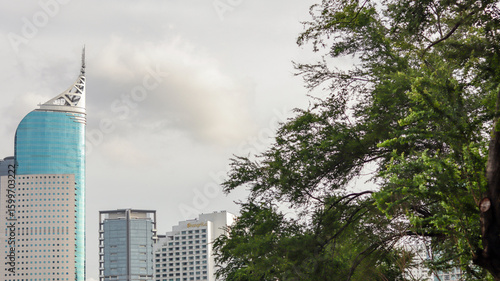 view of a public park with a lake in Jakarta in the morning with a background of modern buildings on the lake side