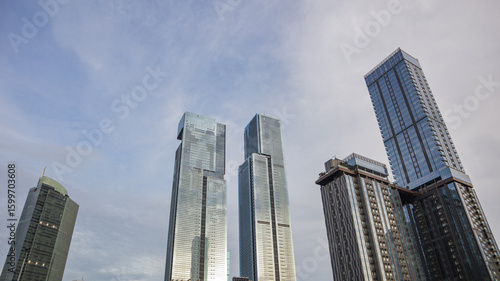 view of a public park with a lake in Jakarta in the morning with a background of modern buildings on the lake side