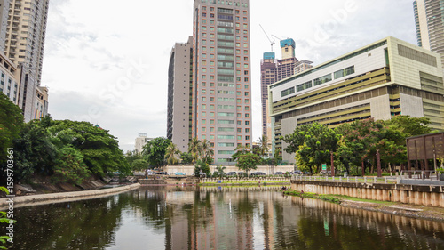 view of a public park with a lake in Jakarta in the morning with a background of modern buildings on the lake side