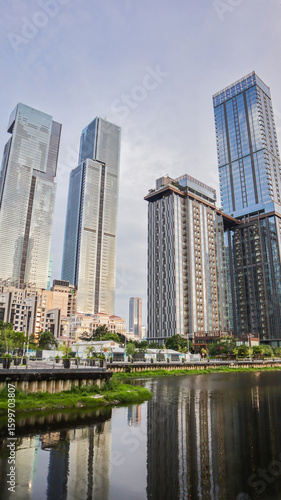 view of a public park with a lake in Jakarta in the morning with a background of modern buildings on the lake side