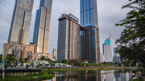 view of a public park with a lake in Jakarta in the morning with a background of modern buildings on the lake side