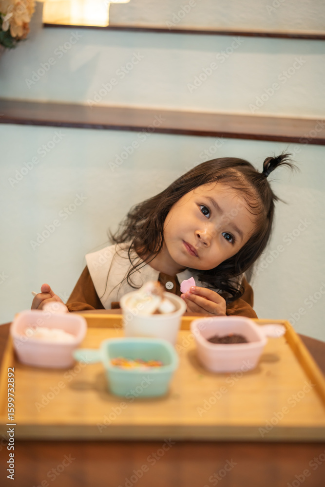 toddler girl eating ice cream dessert with spoon toddler girl eating ice cream dessert with spoon