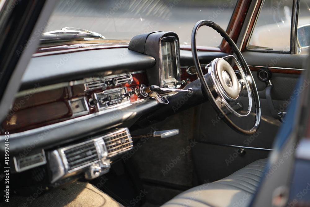 Obraz premium Vintage Classic car steering wheel, with chrome and leather textures in sharp detail, showcases the quality and precision of automotive craftsmanship under natural light.