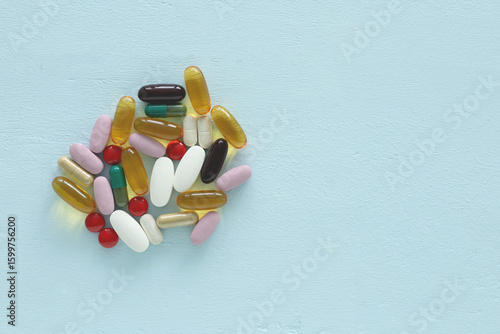Fotografía Flat lay with copy space of assorted supplement pills and capsules on a light blue wooden backdrop
