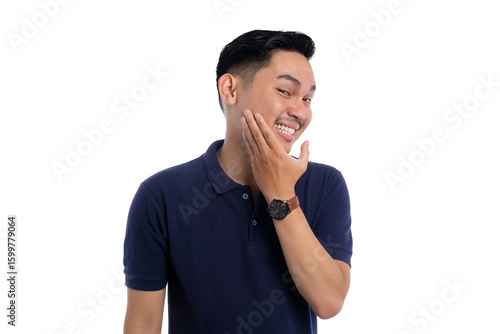 Canvas Print Playful smiling man touching face with one hand while showing bashful expression