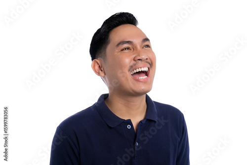 Happy young man laughing joyfully while looking up wearing navy blue polo shirt isolated on transparent background