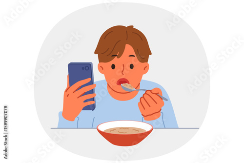 Boy suffering from digital addiction eats and watches video on mobile phone at same time. Schoolboy needs help of psychologist to combat addiction to phone and use of social networks