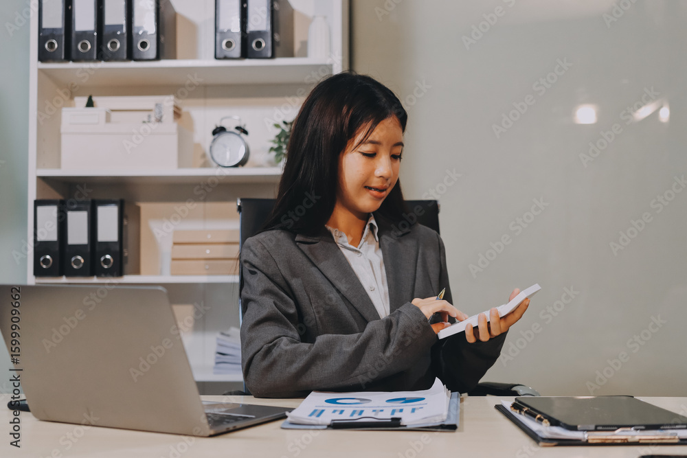 Portrait of Young Asian woman hand freelancer is working her job on computer tablet in modern office. Doing accounting analysis report real estate investment data, Financial and tax systems concept. Portrait of Young Asian woman hand freelancer is working her job on computer tablet in modern office. Doing accounting analysis report real estate investment data, Financial and tax systems concept.