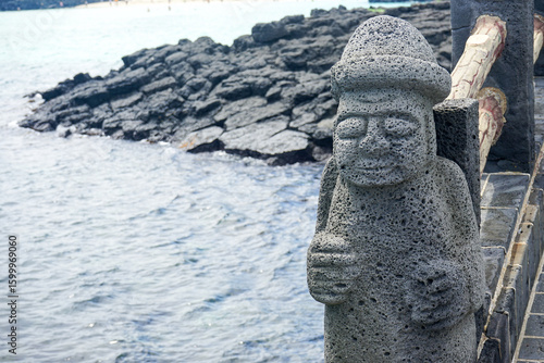 Close up view of a stone grandfather (Dol hareubang) volcanic rock statue at Hamdeok Beach on Jeju Island, South Korea