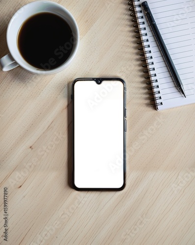 A smartphone with a blank white screen, a cup of coffee, and a notebook on a wooden table.