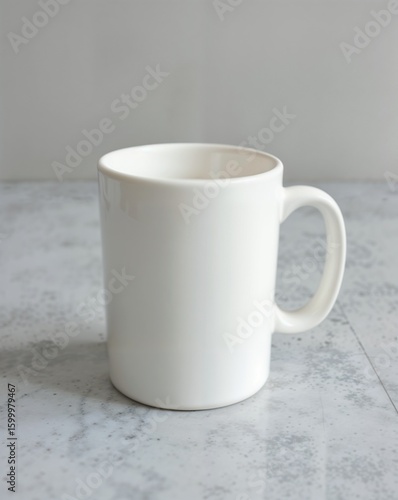 A white ceramic mug with a handle on a marble table. The background is a clean, light gray surface, providing a simple and elegant contrast to the mug.