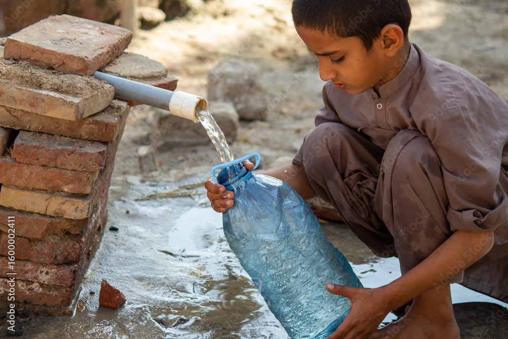 Φωτογραφία Young Pakistani Boy Collecting Clean Water from Outdoor Tap in Village | Daily L