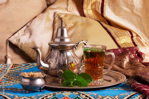 still life with traditional Arabic mint tea in drinking glasses and silver traditional silver pot