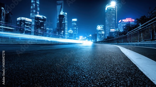 City street at night with illuminated skyscrapers and car light trails.