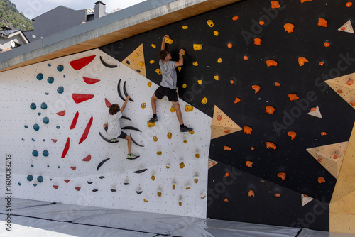 Children climbing artificial rock wall in bouldering gym