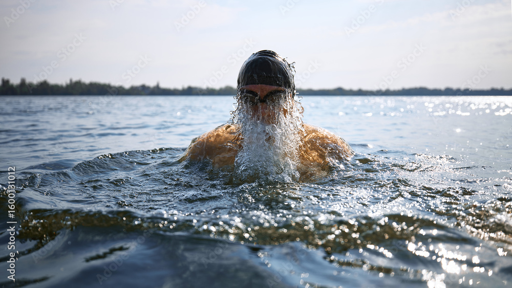 Obraz premium Senior swimmer emerging from water with intense strength. Concept of aging vitality, mature athleticism, endurance training, senior fitness campaigns, and health awareness visuals.