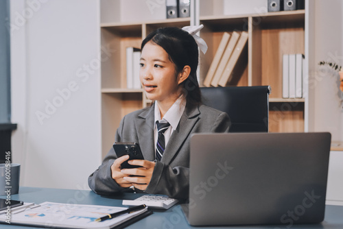 Photography Portrait of a happy Asian businesswoman using mobile phone indoor, Asian businesswoman working in modern office