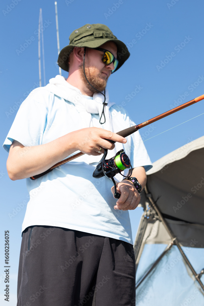 Obraz premium fisherman fishing, Fishing rod, spinning, fisherman against blue sky