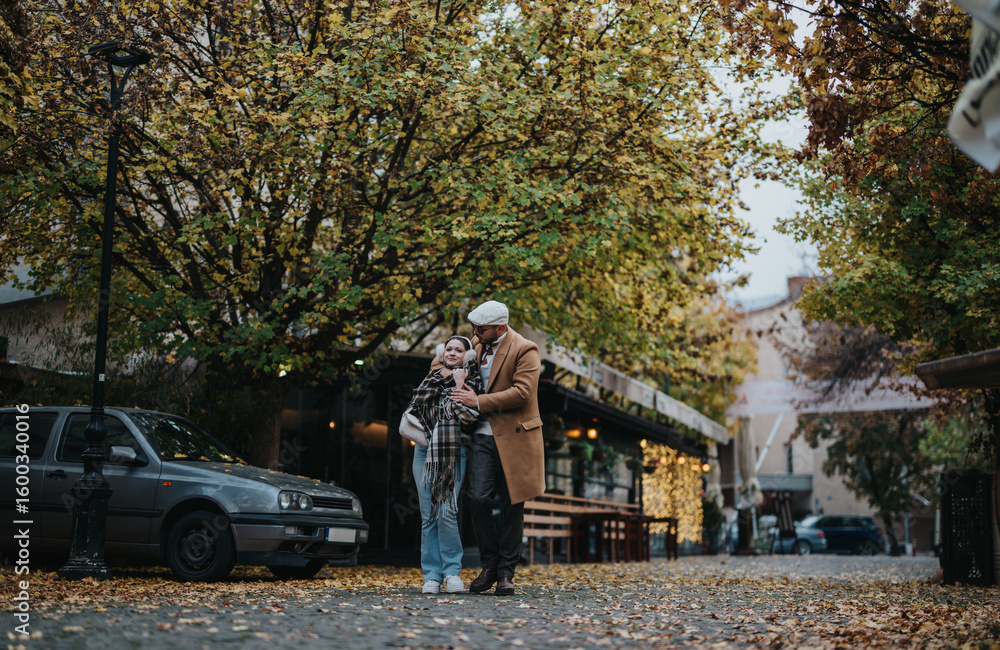 Obraz premium A young couple takes a leisurely walk under colorful autumn trees in an urban setting. The scene captures the essence of romance and tranquility in a bustling city atmosphere.