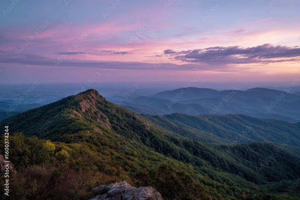 Obraz premium Lush mountains at sunset under a pink and purple sky create a serene vista