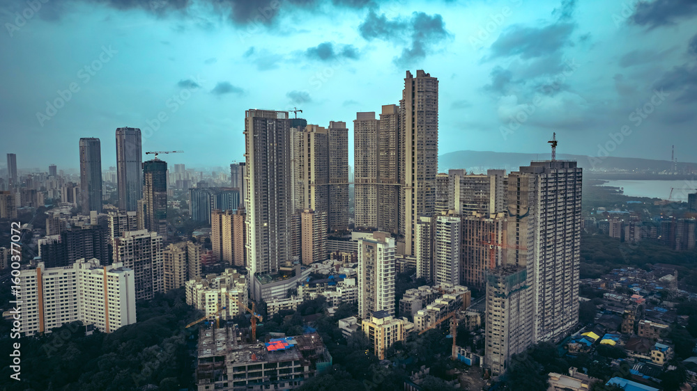 Fototapeta premium Aerial cinematic image of Mumbai during the monsoon season, featuring dramatic clouds over the city skyline. Aerial view of the Bandra-Worli Sea Link in Mumbai, India.