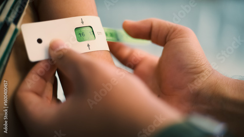 A doctor examines children's malnutrition inside a refugee camp. Malnutrition was measured using a mid-upper arm circumference belt.