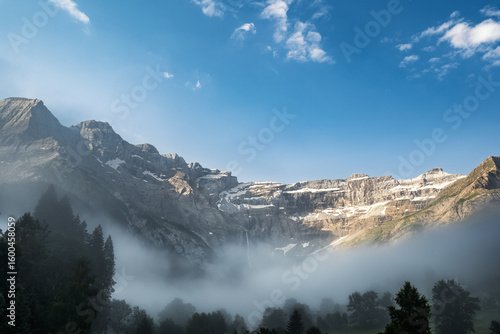 Early morning mist hanging in the valley at the Cirque de Gavarnie, a UNESCO World Heritage site with the highest waterfall in France, in the French Pyrenees