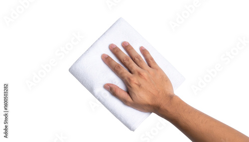 A hand is wiping a white surface with a folded white cloth against a black background.