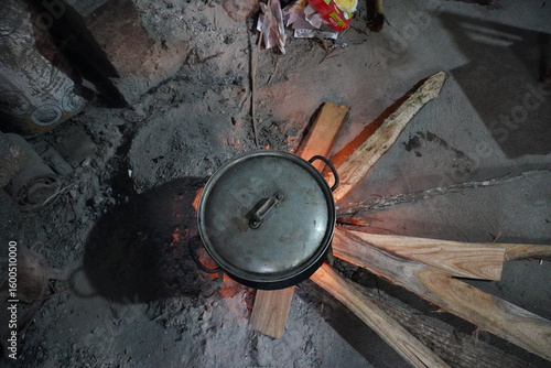 Cooking pot on fire with wood underneath