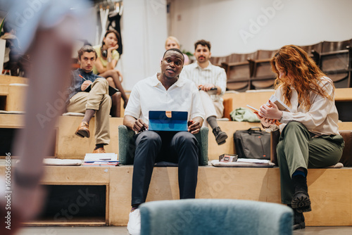 Several people collaborate in a relaxed environment, fostering creativity, teamwork, and progression through open communication, shared workspace, and contemporary tools.