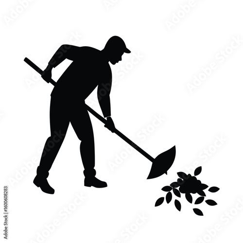 Silhouette of a man raking autumn leaves.