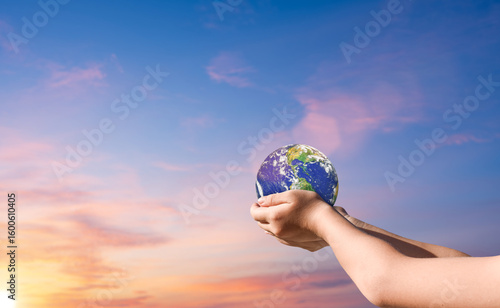 Fototapeta Naklejka Na Ścianę i Meble -  Hand holding globe, earth over sunset sky background. Elements of this image furnished by NASA