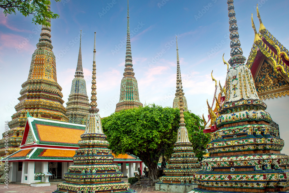 Fototapeta premium Buddhist pagodas of Wat Phra Chetuphon - Wat Pho temple in Bangkok, Thailand, decorated with colorful tiles