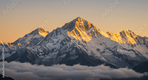 Majestic mountain peaks bathed in golden light above a sea of clouds at sunrise.