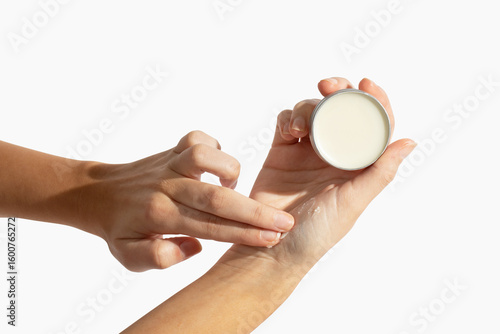 Fotografie Applying balm on girl hand on white background
