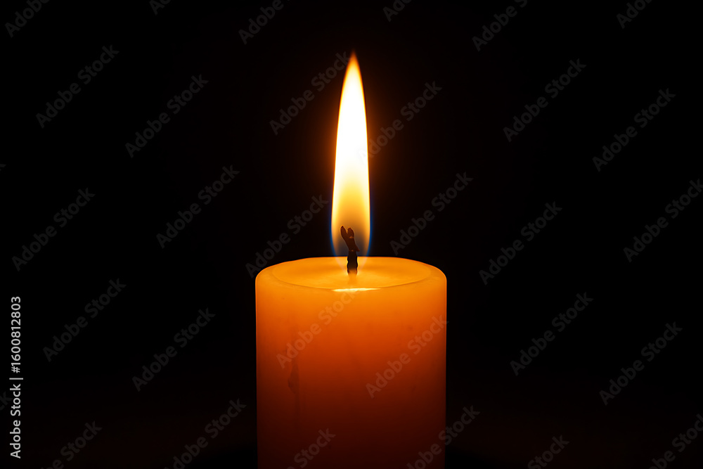 Burning candle with bright flame in darkness, close up of glowing candlelight for meditation, relaxation, or remembrance concepts Burning candle with bright flame in darkness, close up of glowing candlelight for meditation, relaxation, or remembrance concepts