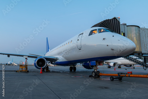 Modern passenger airliner at the skybridge on the airport early in the morning