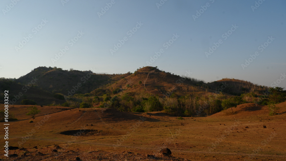 Arid Landscape With Brown Hills And Sparse Vegetation Arid Landscape With Brown Hills And Sparse Vegetation