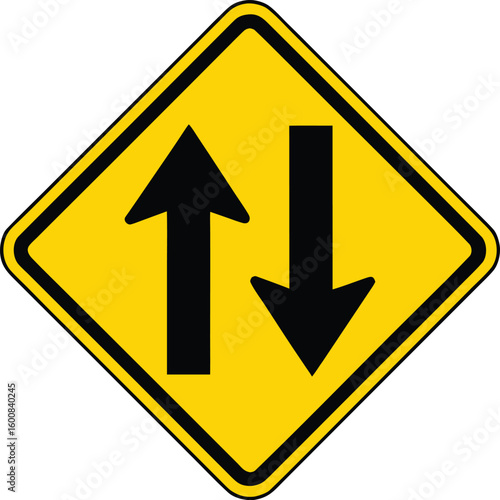 Yellow diamond traffic sign with two opposing arrows indicating two way traffic.