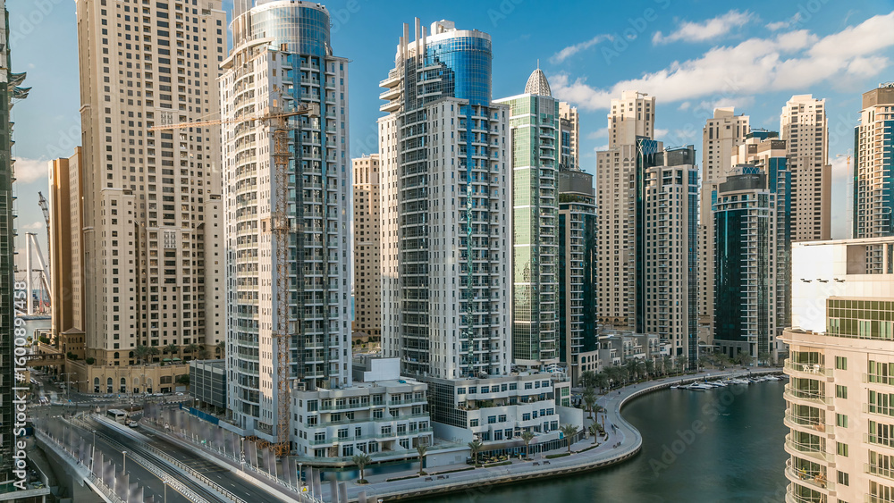 Fototapeta premium Dubai Marina at evening timelapse with trails of boats on the water and cars traffic, Dubai, UAE