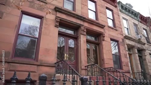 View of brownstone houses with ornate doors and iron railings in a city neighborhood