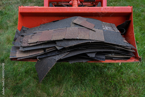 Old Asphalt Shingles in Loader Bucket After Roof Tear-Off