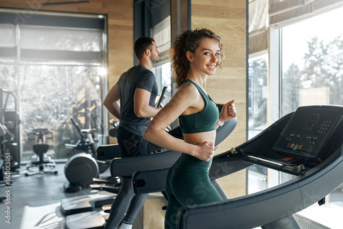 Foto Funny gym moment with young couple during leg press workout
