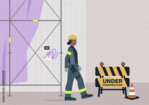 A construction site worker diligently focused on their tasks amidst barriers and scaffoldings, showcasing teamwork and dedication at an urban construction site.