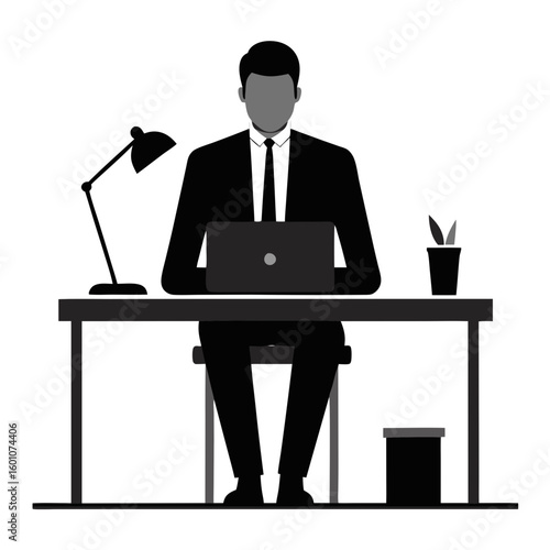 Businessman working on a laptop at a desk with a lamp and trash can