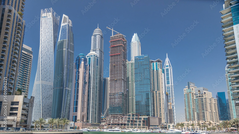 Fototapeta premium Panoramic view with modern skyscrapers and yachts of Dubai Marina timelapse, United Arab Emirates