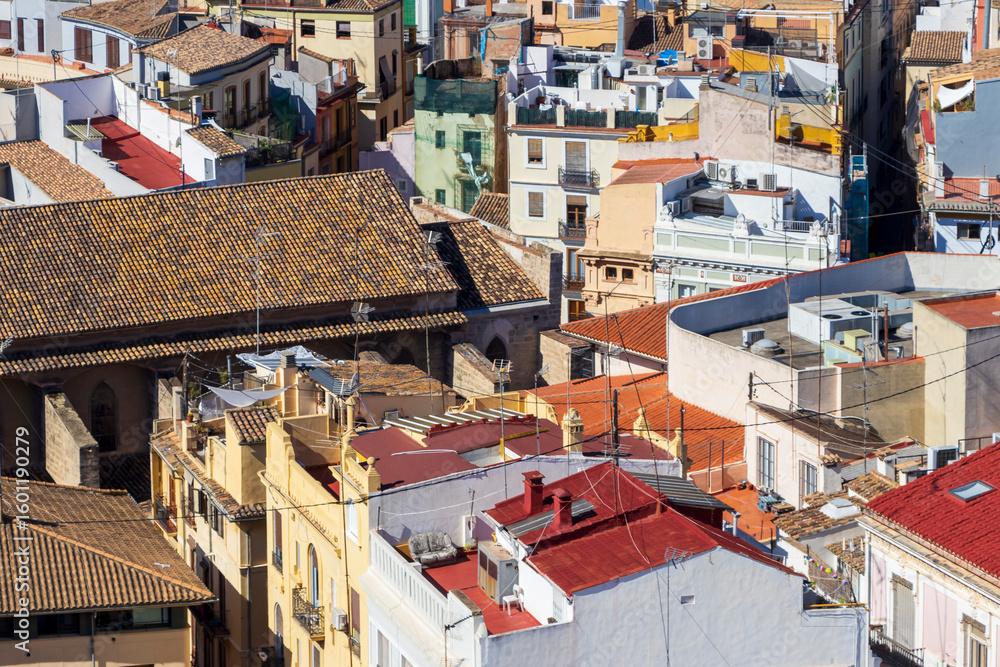 Fototapeta premium Aerial view of densely packed rooftops in Valencia, showcasing a mix of traditional tile designs and modern structures. Exploring the vibrant urban landscape.