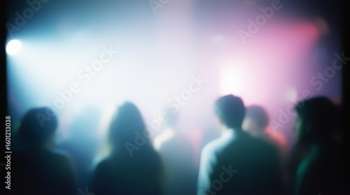 Atmospheric nightclub scene with blurred figures and bright beams of light