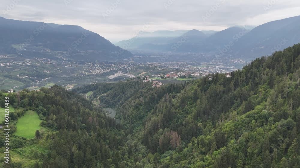 Flight towards mountain panorama of Passeier Valley with village Tirol (Dorf Tirol), city Merano (Meran) and clouds in South Tyrol, Italy Flight towards mountain panorama of Passeier Valley with village Tirol (Dorf Tirol), city Merano (Meran) and clouds in South Tyrol, Italy