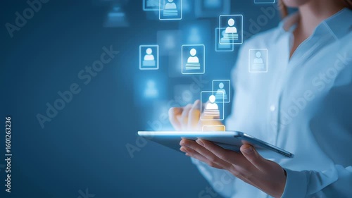 Businesswoman using a digital tablet with floating holographic user icons representing data or profile access. Concept of HR technology, recruitment and digital identity management
